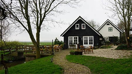 De tuin van Koffiepunt 40 met een zwart houten huis